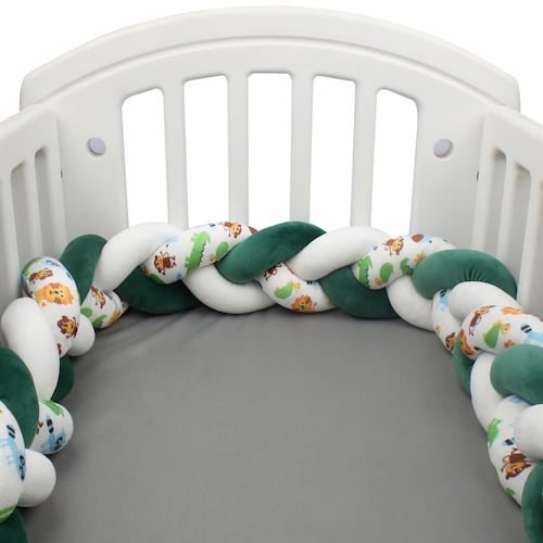 Tresse de lit bébé verte et blanche tressée installée autour d’un berceau blanc
