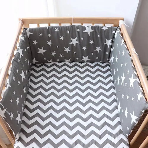 Tour de lit bébé complet motif etoiles blanches installe dans un lit en bois