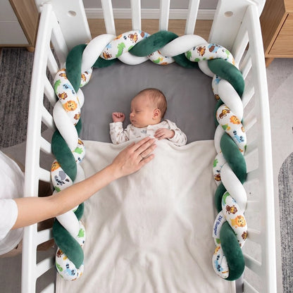 Bébé dort dans son lit avec une tresse de lit bébé verte et blanche autour du berceau