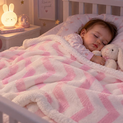 Bébé dort la nuit avec une couverture bébé rose à motifs chevrons