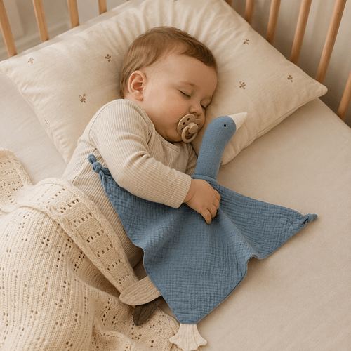 Bébé dort paisiblement avec un doudou oie bleu en gaze de coton compagnon doux et réconfortant