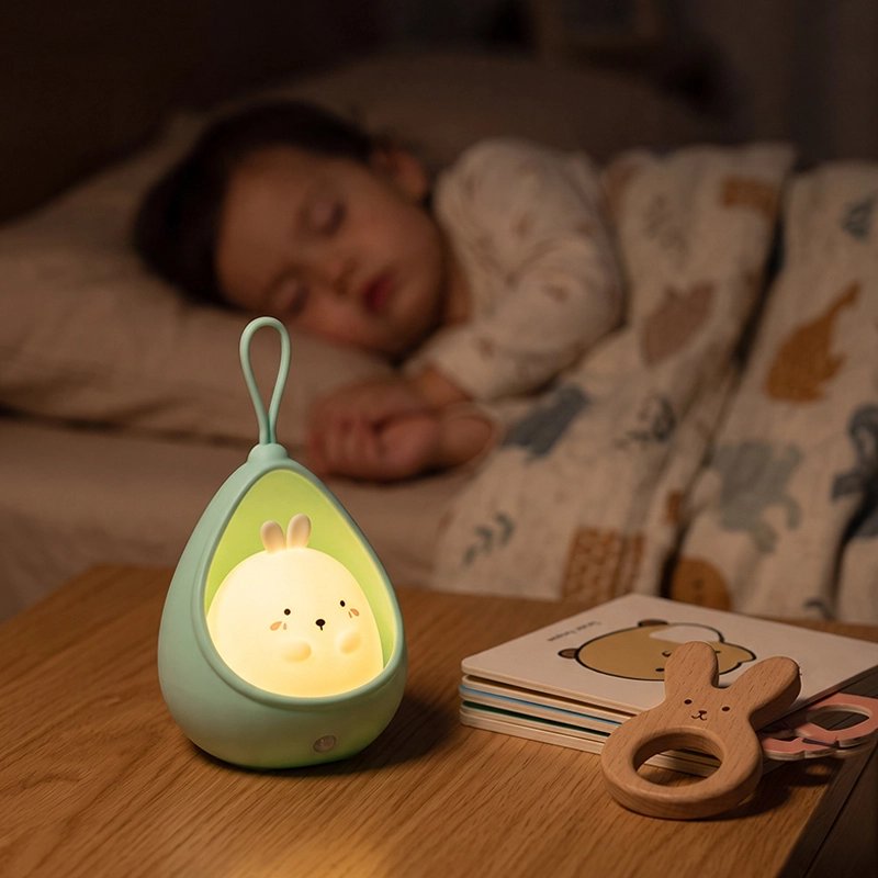 Bébé dort paisiblement avec une veilleuse pour bebe lapin posée près du lit