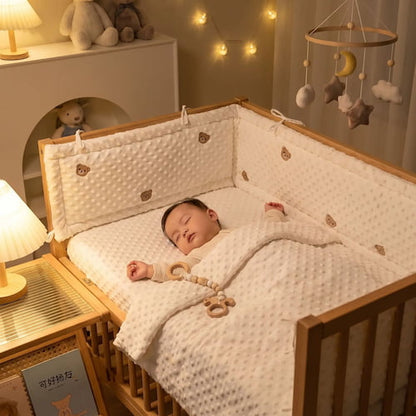 Bébé dort paisiblement dans son lit avec un tour de lit respirant motif ours