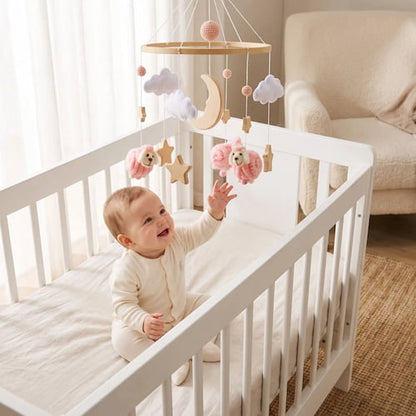 bebe joue dans son lit entoure de mobile bébé mouton rose