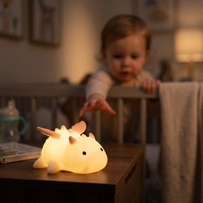 Bébé observant une veilleuse bébé dinosaure lumineuse créant une ambiance douce et rassurante