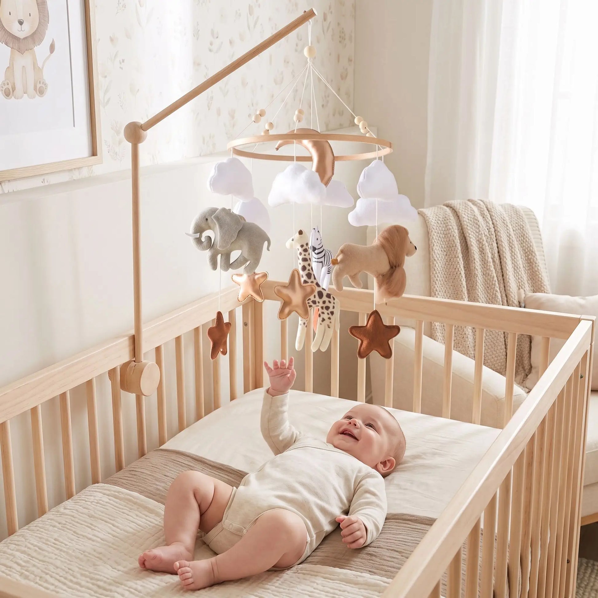 Bébé souriant dans son lit avec un mobile bébé animaux de la savane au-dessus de lui