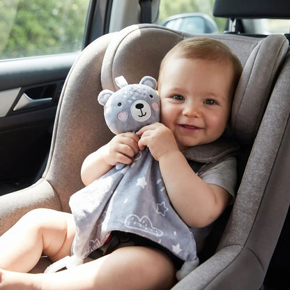 bebe souriant dans un siege auto tenant un doudou bebe garcon ours gris pour un trajet confortable