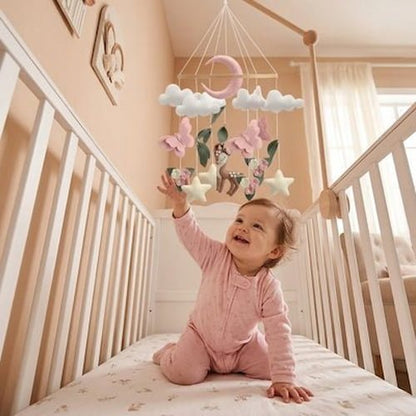 Bébé souriant découvre un mobile bébé suspendu au-dessus de son lit