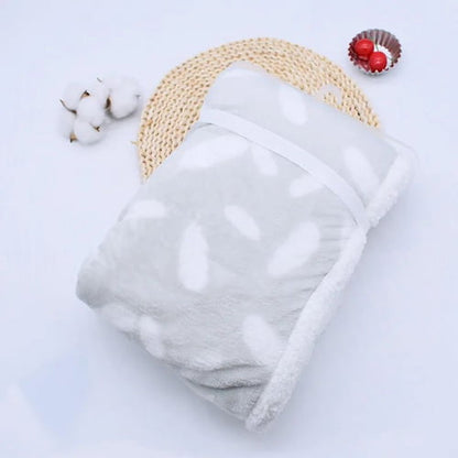 Couverture bébé grise à motifs cœurs pliée avec bordure douce