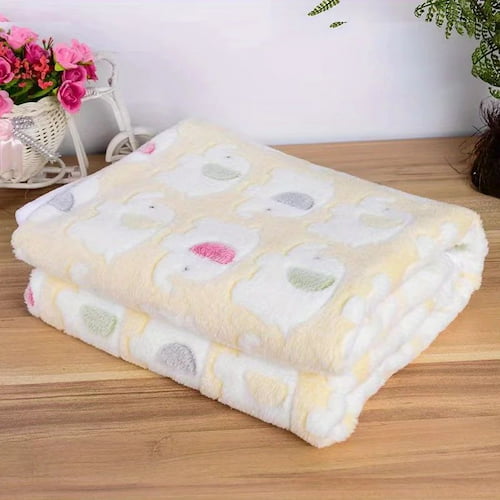 Couverture bébé polaire jaune douce à motifs d’éléphants pliée et présentée sur une table
