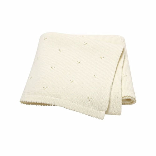 couverture bebe tricot blanc soigneusement pliee montrant sa texture douce et ses petits motifs