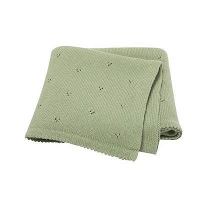 couverture bebe tricot verte soigneusement pliee montrant sa texture douce et ses petits motifs