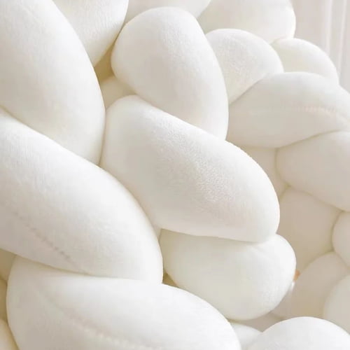 Gros plan sur la texture douce d’une tour de lit tressée blanche
