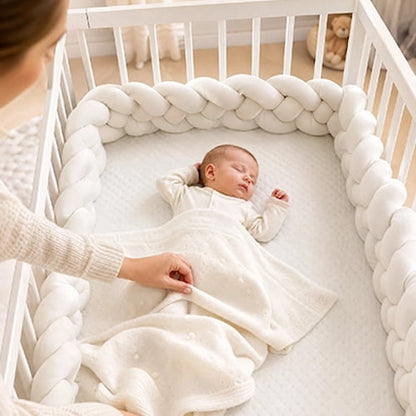 : Maman ajuste une tour de lit tressée blanche autour du bébé endormi
