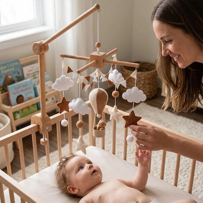 maman pres du berceau avec mobile pour bebe montgolfiere beige