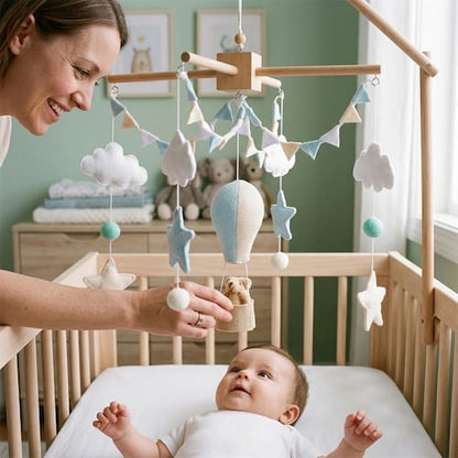 maman presente a bebe un mobile pour bebe montgolfiere bleu avec nuages et etoiles