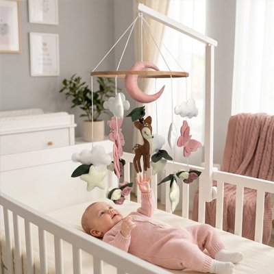 Mobile bébé avec lune, nuages, étoiles et fleurs suspendu au-dessus du berceau