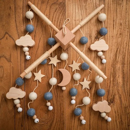 Mobile bebe etoiles et lunes en bois au couleur bleu presente sur fond en bois