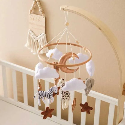 Mobile bébé safari avec animaux, nuages, lune et étoiles dans une décoration douce pour la chambre.