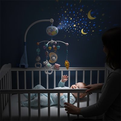 Mobile musical bébé avec figurines colorées suspendues au-dessus du lit et lumière douce