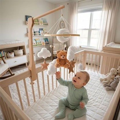 Mobile pour bébé en bois naturel avec ourson, nuages et étoiles dans une chambre lumineuse