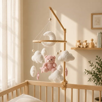 Mobile pour bébé ours rose installé au-dessus d’un berceau en bois dans une chambre douce