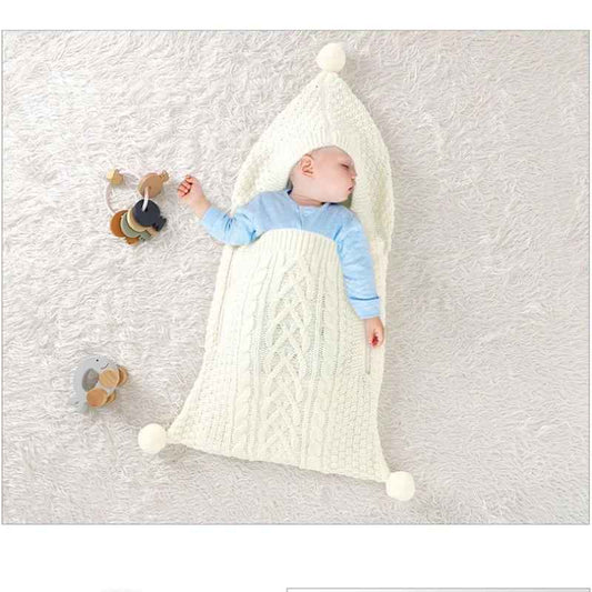 nid d ange cosy en maille tricotee ecrue avec capuche a pompon bebe endormi motif torsade doux et confortable
