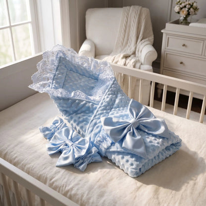 nid pour bebe bleu en tissu minky doux avec dentelle et grand nœud, posé dans un lit de bébé