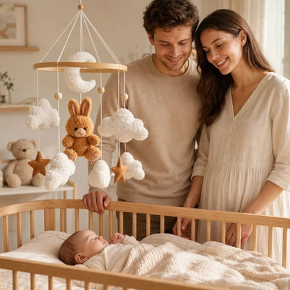Parents admirant bébé endormi sous mobile lit bébé lapin marron
