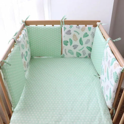Tour de lit bebe vert à motifs de feuilles installé dans un berceau