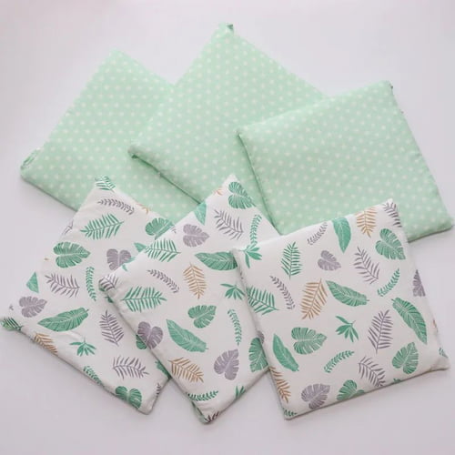 Tour de lit bebe vert à motifs feuilles présenté en plusieurs pièces