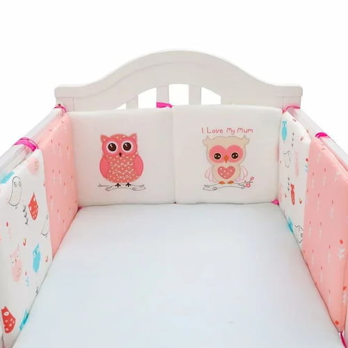 Tour de lit rose à motifs hiboux installé tout autour du berceau