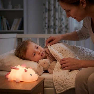 Veilleuse bébé en silicone diffusant une lumière douce près d’un enfant au coucher avec sa maman