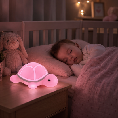 Veilleuse tortue rose diffusant une lumière douce sur une table de chevet dans la chambre d'un bébé endormi
